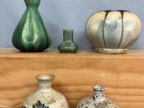trois vases posés les uns à côté des autres sur une étagère en bois