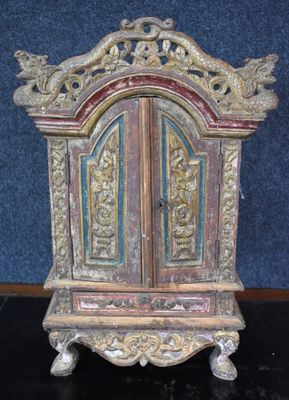 un petit meuble en bois surmonté d'une porte