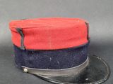 une image représentant un chapeau rouge et bleu posé sur une surface noire