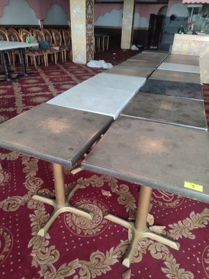 Des tables et des chaises sont alignées dans une pièce recouverte d'un tapis rouge