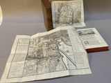 deux vieilles cartes sont posées sur une table à côté d'une lampe
