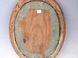 a wooden plate with a green rim on a white wall