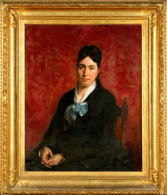 portrait d'un homme en costume noir et nœud papillon, assis sur une chaise