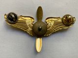a gold pin with a bird on it on a white surface