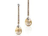 une photo d'une paire de boucles d'oreilles en diamants jaunes et blancs