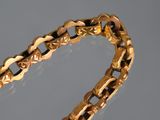 a close up of a gold bracelet on a gray surface