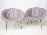 une paire de chaises violettes aux pieds chromés sur fond blanc
