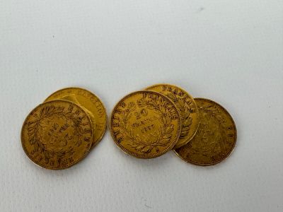 a close up of three gold coins on a white surface