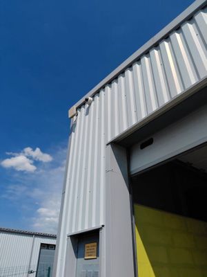 une porte jaune devant un immeuble, avec un ciel bleu en arrière-plan