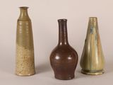 three vases are sitting next to each other on a white surface