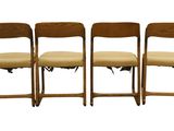three wooden chairs sitting next to each other on top of a white surface