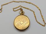 an image of a gold pocket watch with a chain on a white surface