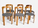 quatre chaises en bois avec des coussins d'assise gris sur fond blanc