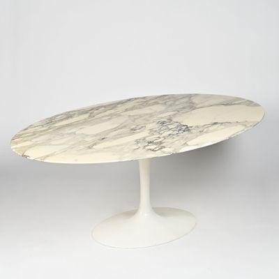 une table ovale en marbre avec un piètement blanc et un piètement blanc