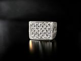 a white gold and diamond ring on a black surface