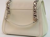 beige leather handbag with silver chain handles on a white surface