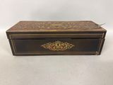 a wooden box with a gold and red design on it