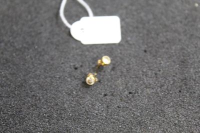 a small piece of jewelry on the ground next to a tag