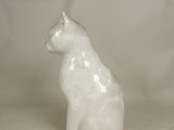 a white cat figurine sitting in a bowl