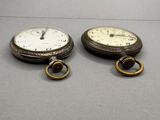two clocks that are sitting next to each other on a table
