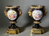 pair of antique vases with painted flowers on them sitting on a table