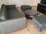 un salon avec un canapé, un fauteuil, une table basse et une télévision