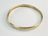 une image d'un gros plan d'une bague en or sur une surface blanche