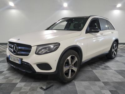 Une Mercedes GL blanche est garée sur un sol à damier.