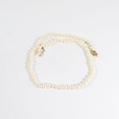 un collier de perles blanches avec un fermoir en or et un fermoir en or