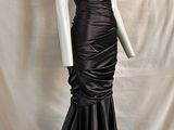 une image représentant un mannequin vêtu d'une robe noire, sur un autre mannequin