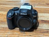 a camera sitting on a wooden table with a flash drive attached to it