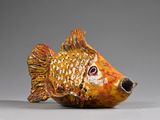 un petit poisson en céramique posé sur une table