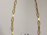 gros plan d'un collier en chaîne en or sur fond blanc