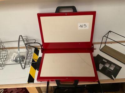 une valise rouge posée sur une table, avec une étiquette de prix dessus