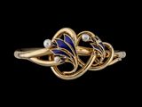 gros plan d'une bague en or avec des pierres bleues et blanches