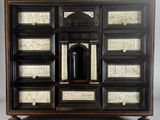 an image of a black and white chest of drawers with a clock on top of it