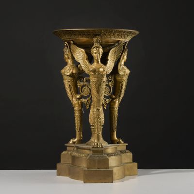 un vase antique en bronze orné d'une femme et de deux hommes