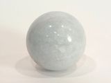 une boule de marbre blanc posée sur une surface blanche