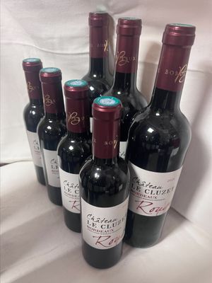 six bouteilles de vin rouge alignées sur une table