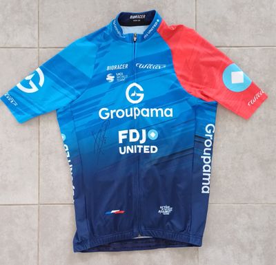 un gros plan sur un maillot bleu et rouge posé sur un sol carrelé