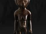une statue en bois d'un homme avec un chapeau sur la tête