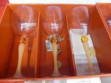 three wine glasses in a box with gold handles