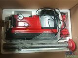 a box with a red machine inside of it