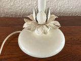a white table lamp with a flower on top of it