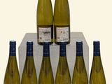 six bottles of white wine sitting on top of a wooden block