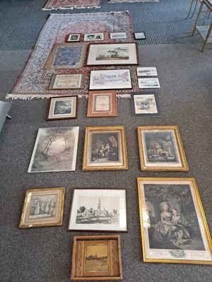 a lot of framed pictures on the floor of this room