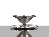 une assiette en argent sur laquelle est posée une soucoupe en argent