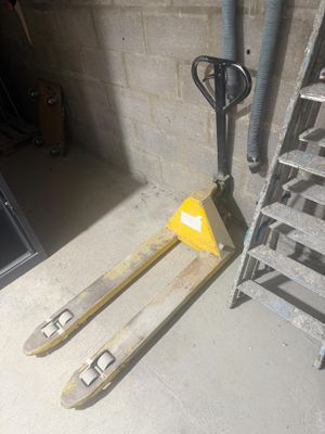 une fourche et une palette à côté d'un escalier