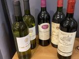 plusieurs bouteilles de vin sont alignées sur une table en bois
