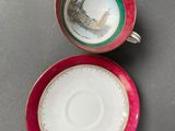 two cups and saucers with a picture of a castle on them